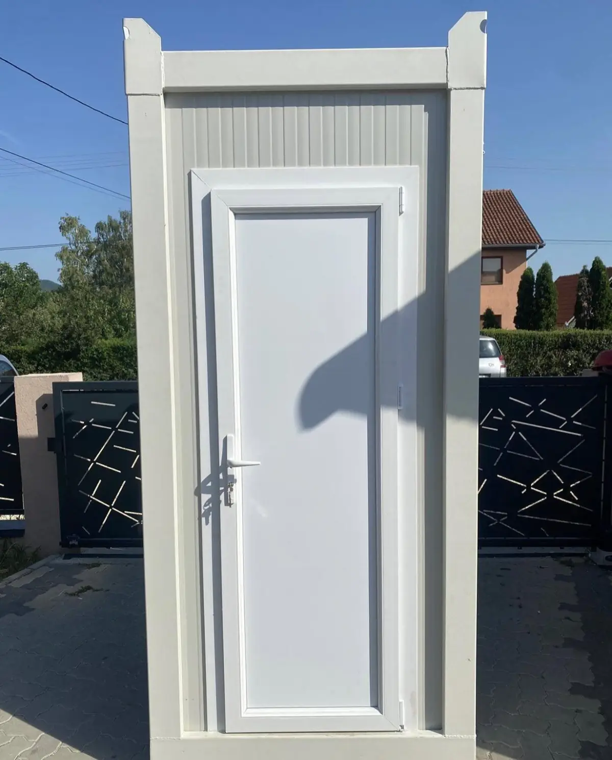 White deluxe flushing porta potty with a full door on a paved lot
