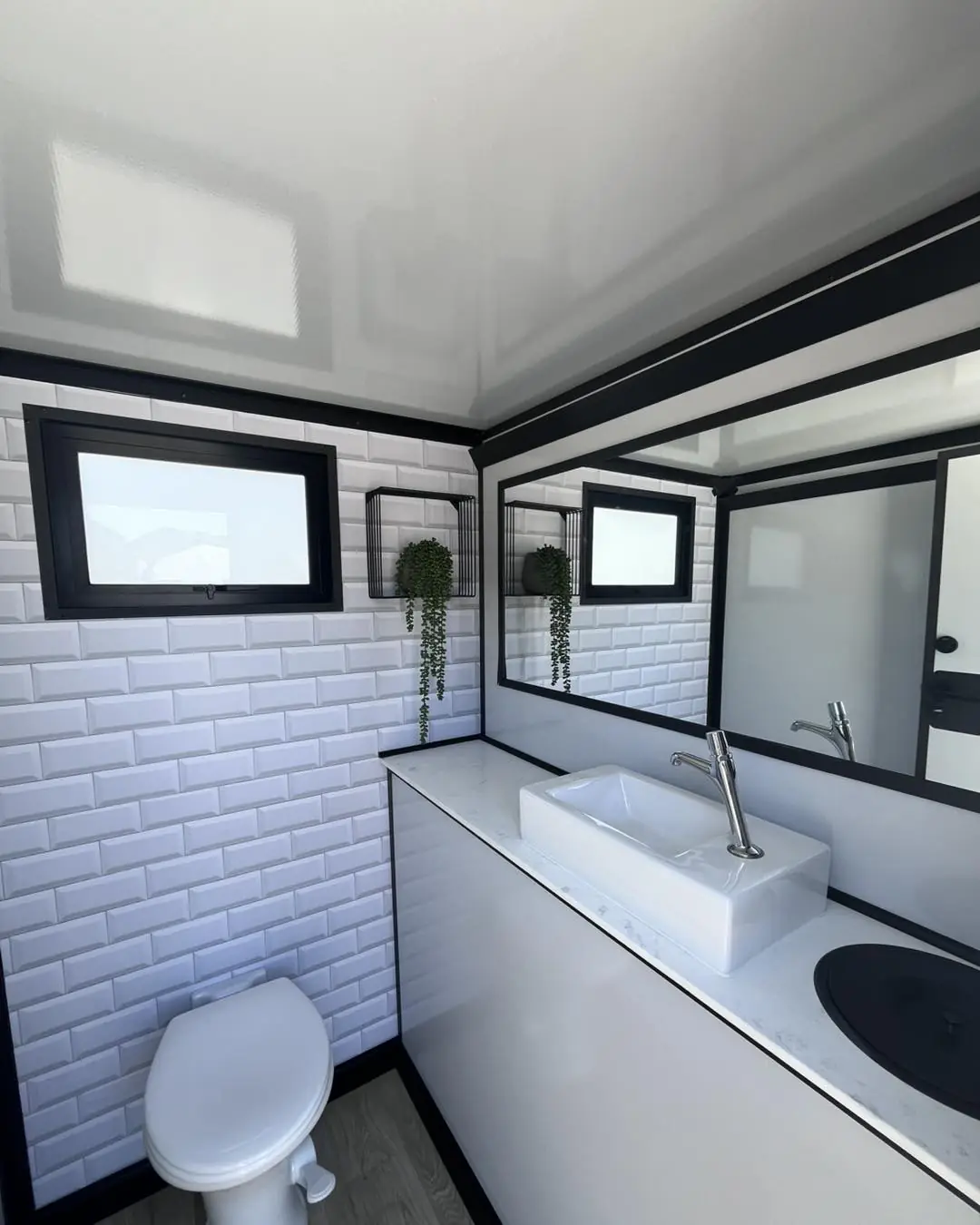 Restroom trailer station with white subway tile, vessel sink and porcelain toilet